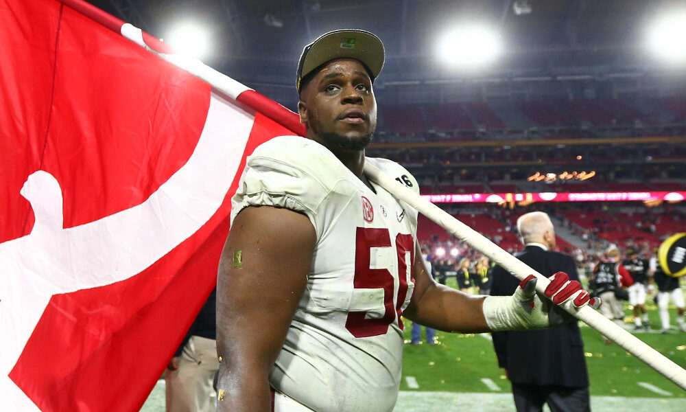 Alphonse Taylor carrying Alabama Crimson Tide flag after winning national championship versus Clemson