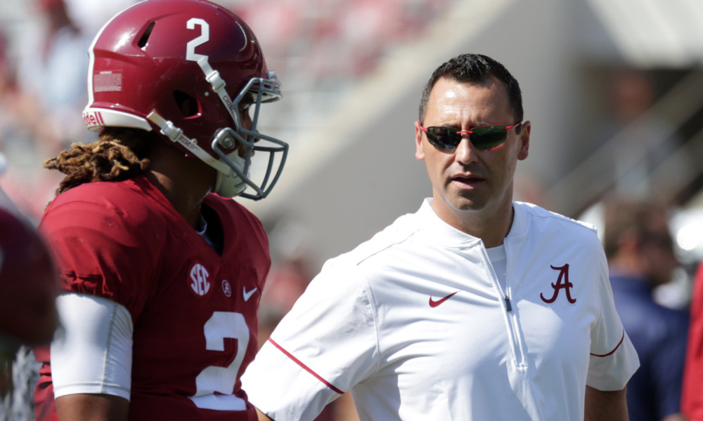 Steve Sarkisian speaking with Jalen Hurts on the field during 2016 season