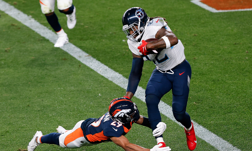 Derrick Henry runs through a tackle of Denver Broncos defender