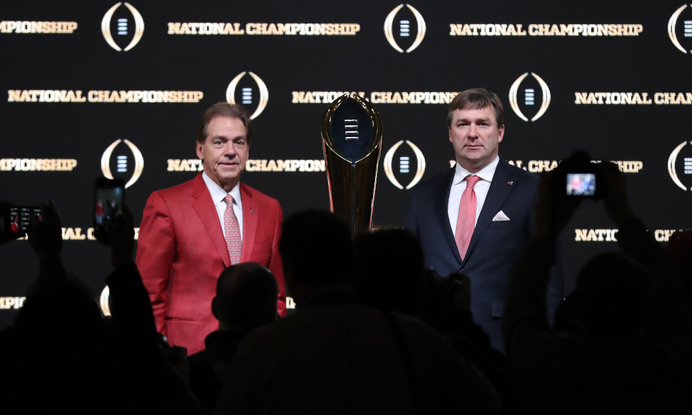 Nick Saban and Kirby Smart standing next to 2018 CFP Trophy in a presser
