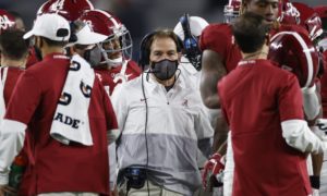 Nick Saban in a huddle during a stoppage