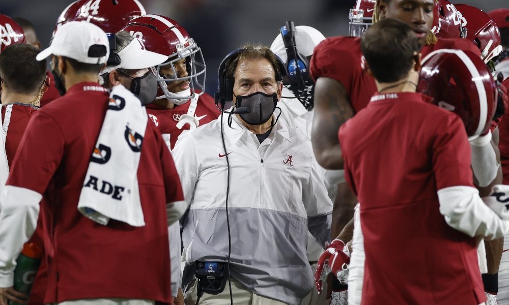 Nick Saban in a huddle during a stoppage