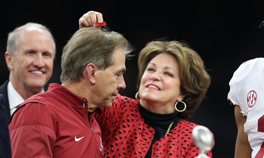 Nick Saban wife Terry Saban removes confetti from his hair