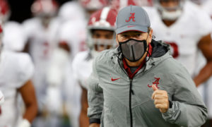 Nick Saban runs on the field for Alabama to face Ole Miss