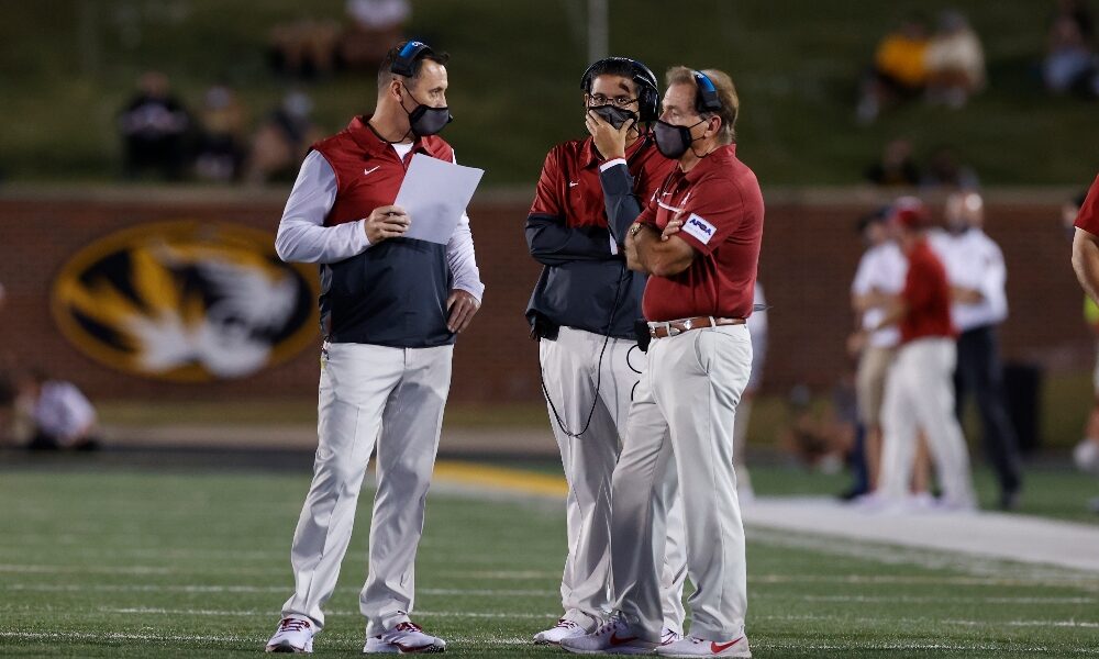 Steve Sarkisian talks to Nick Saban and Jeff Banks on the sideline