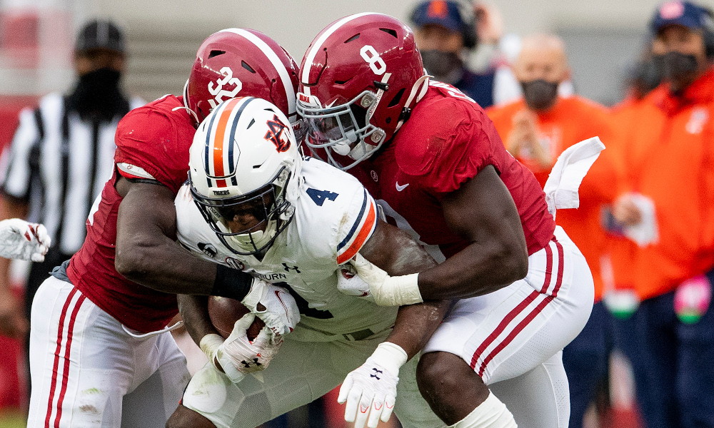 Christian Harris (No. 8) helps Dylan Moses (No. 32) tackle Tank Bigsby of Auburn