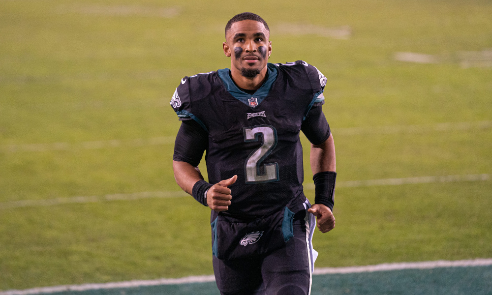 Jalen Hurts runs off the field in celebrating a win for Eagles in his first start