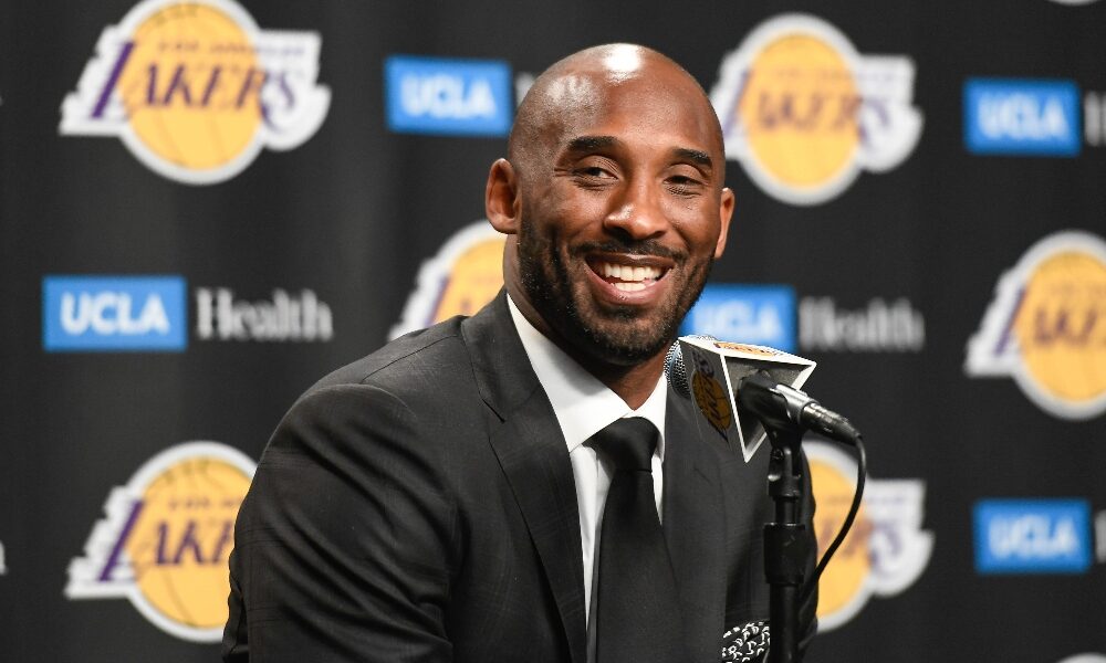 Kobe Bryant smiles while speaking to reporters