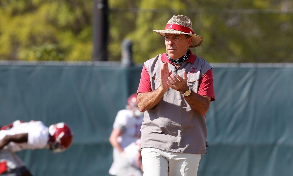 Nick Saban walks along the practice field