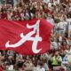 A flag is waved across the stands at Bryant-Denny Stadium
