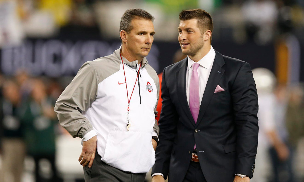 Urban Meyer and Tim Tebow speaking during Ohio State game