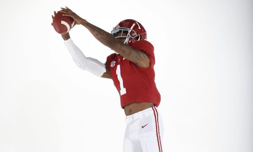 Jameson Williams holds ball in catch position for Alabama in photoshoot