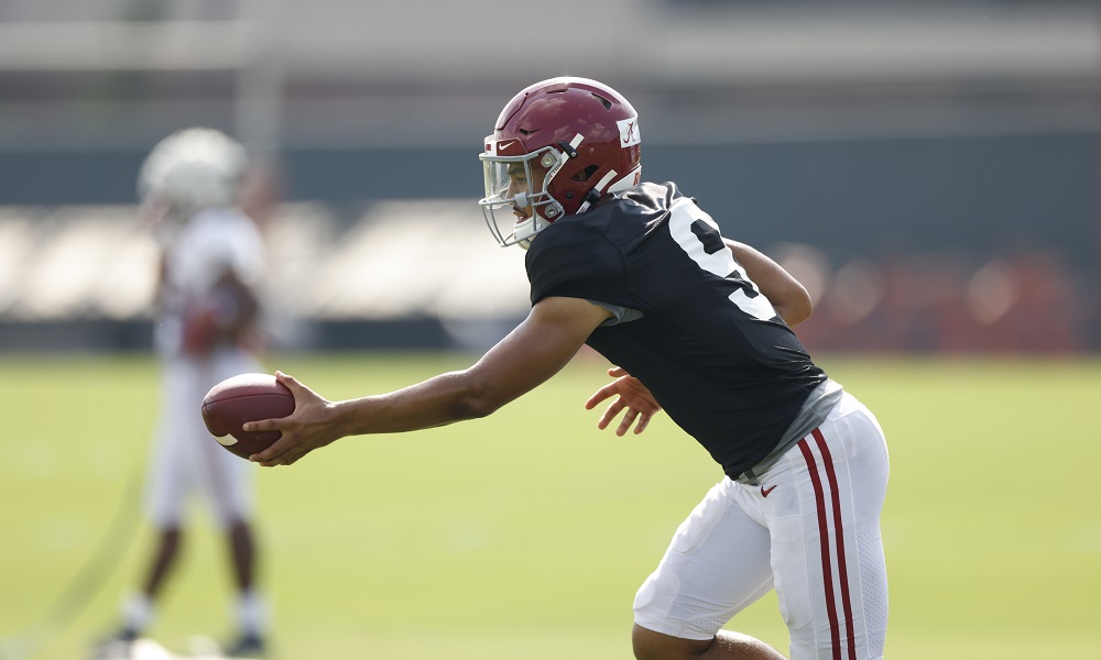Bryce Young executes a hand-off in fall practice for Alabama