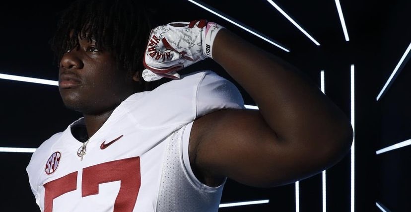 Elijah Pritchett flexes arm for picture during Alabama visit