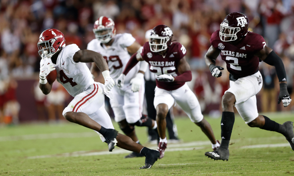 Brian Robinson (#4) runs away from Texas A&M defenders