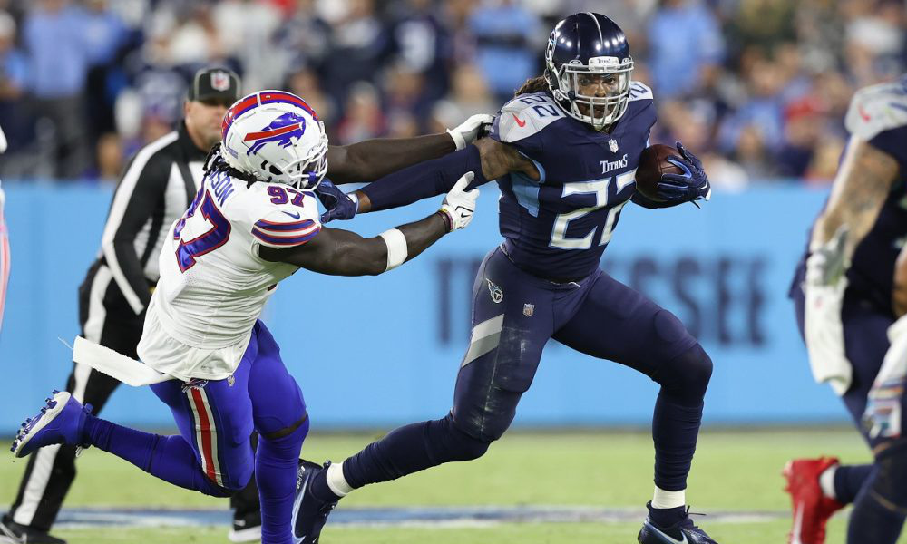 Derrick Henry (#22) stiff arms a Bills' defender to the ground