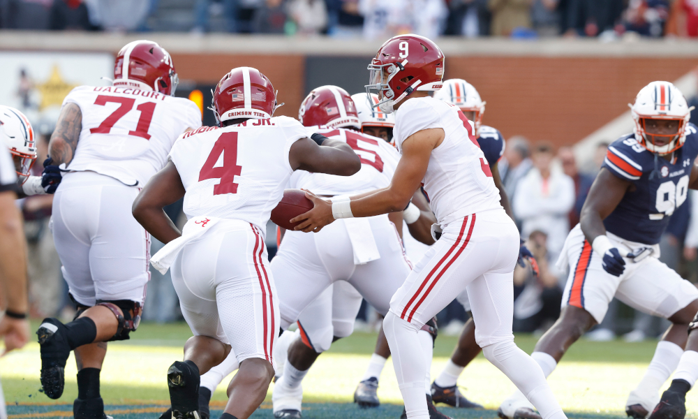 Bryce Young (#9) hands off to Brian Robinson (#4) in Alabama's 2021 Iron Bowl versus Auburn
