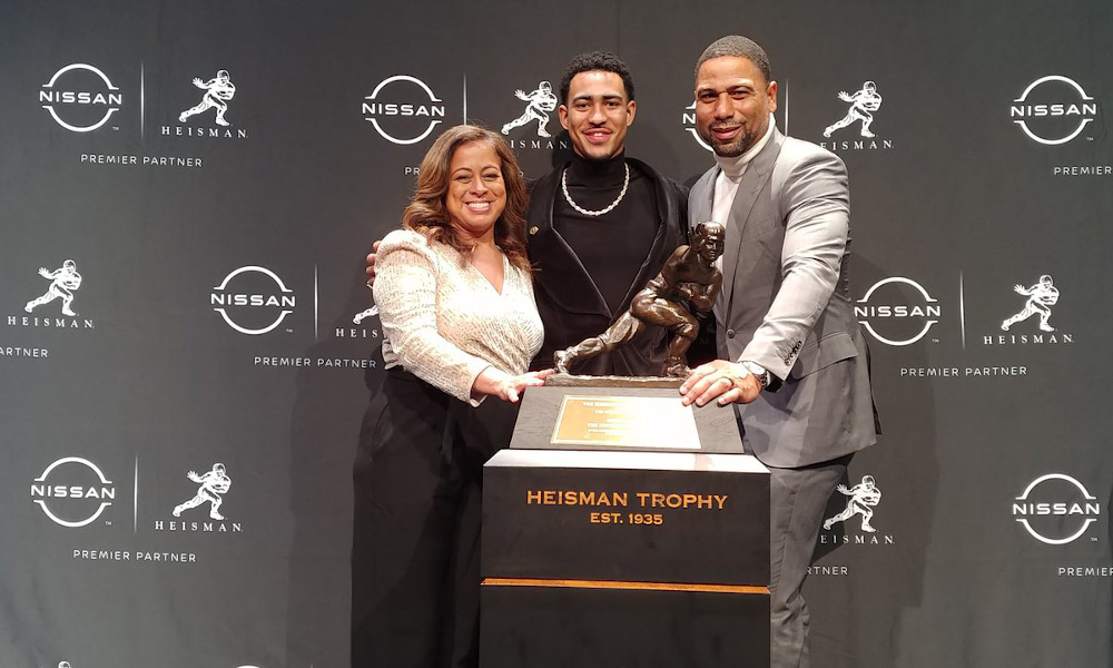 Bryce Young and his parents standing with the Heisman Trophy