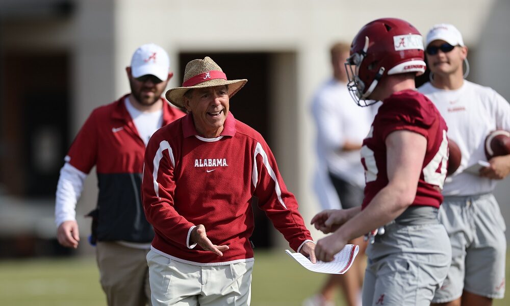 Nick Saban coaching a player during 2022 Alabama spring football practice