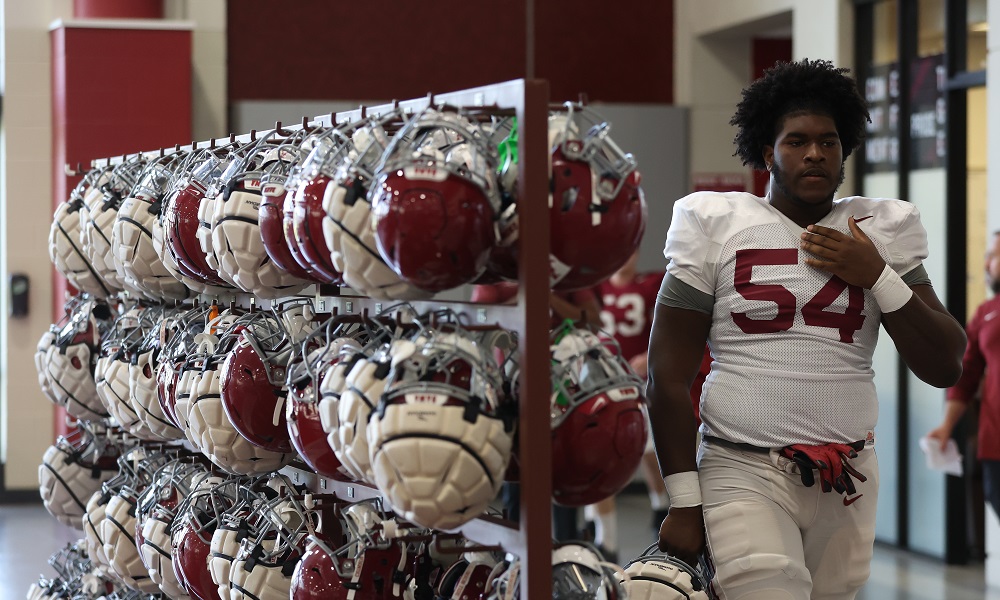 Alabama OL Tyler Booker (#54) grabbing his helmet to work in 2022 Spring Football Practice