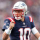 Mac Jones (#10) pumps his fist for the Patriots in 2021 matchup