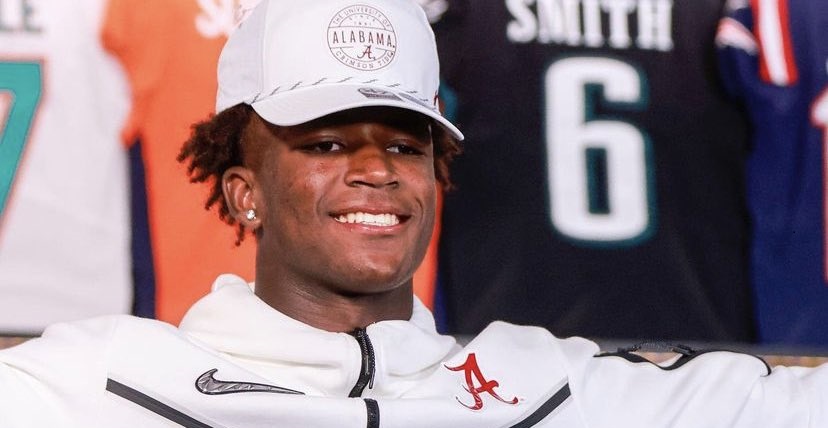 Caleb downs stands with alabama hat