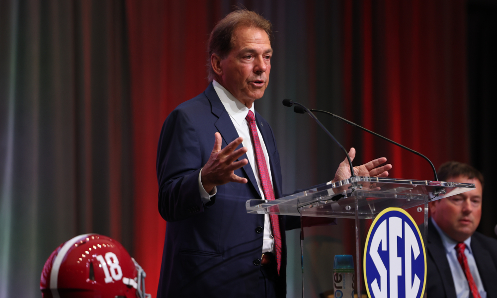 Nick Saban speaks at the podium at 2022 SEC Media Days