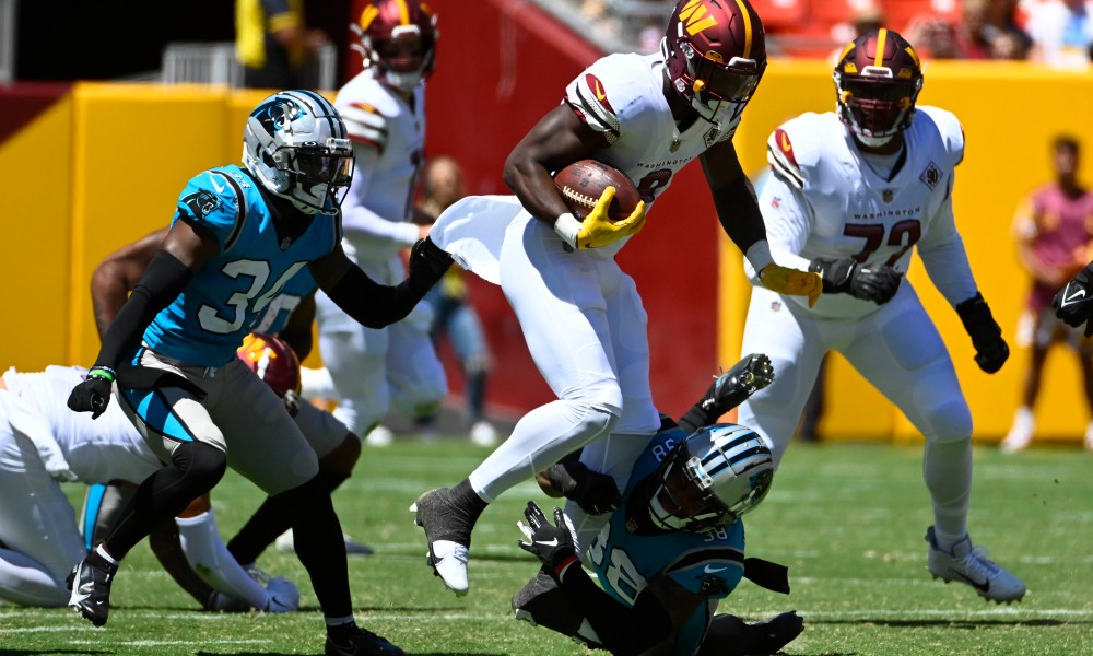 Commanders RB Brian Robinson Jr. (#8) runs through a tackle in NFL Preseason Game versus Panthers