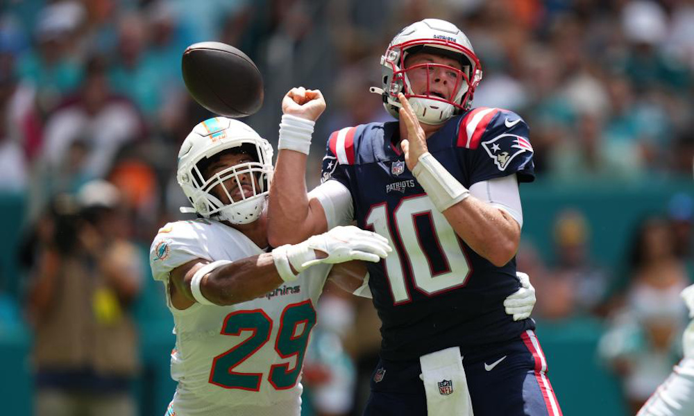 Mac Jones (#10) has ball stripped from him by a Dolphins' defender during Patriots' regular season game