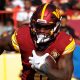 Brian Robinson (#8) runs the ball for Washington Commanders in 2022 game versus Tennessee Titans