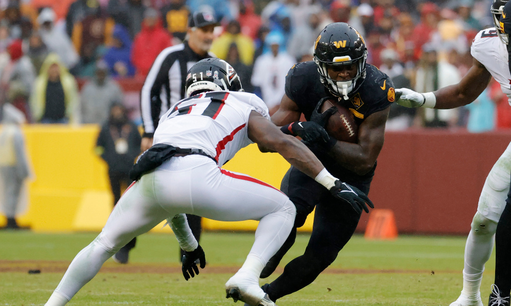 Washington Commanders RB Brian Robinson Jr. (#8) runs the ball against Falcons LB DeAngelo Malone (#51) in Sunday's matchup