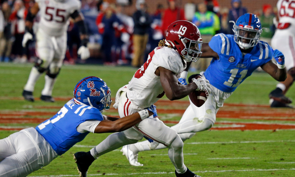 Alabama WR Kendrick Law (#19) runs with the ball through Ole Miss defenders during 2022 matchup against Alabama