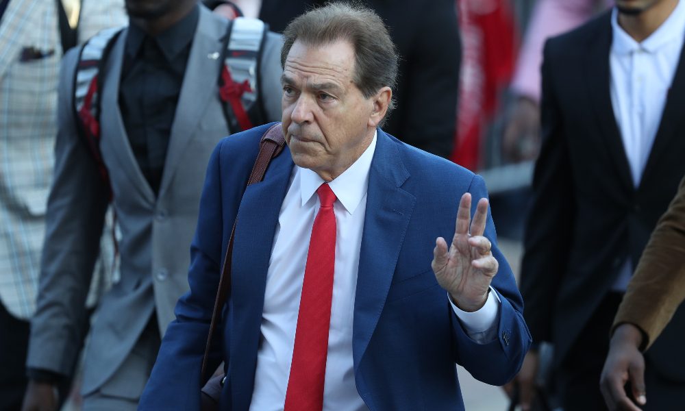 Nick Saban waves to the crowd on the walk of champions
