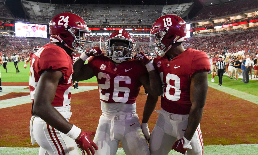 Alabama's Emmanuel Henderson (#24) celebrates a touchdown against Vanderbilt in 2022 game with Jamarion Miller (#26) and Shazz Preston (#18).