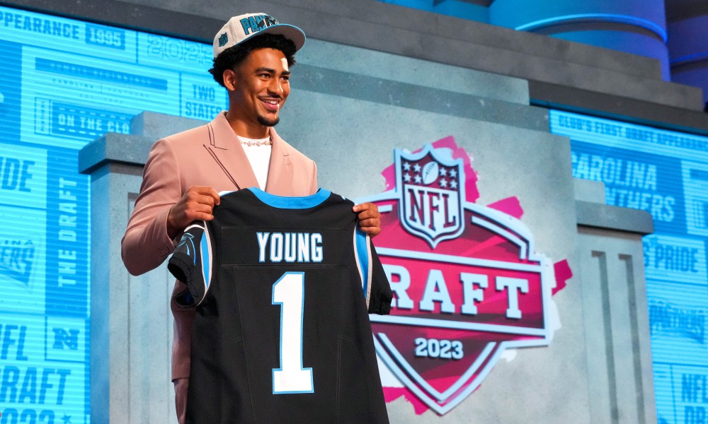 Bryce Young holding a Carolina Panthers jersey as the No. 1 overall pick in 2023 NFL Draft.