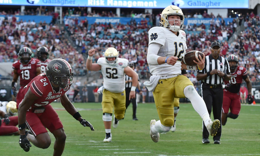 Notre Dame QB Tyler Buchner (#12) runs for a touchdown in the Gator Bowl versus South Carolina to end 2022 season.