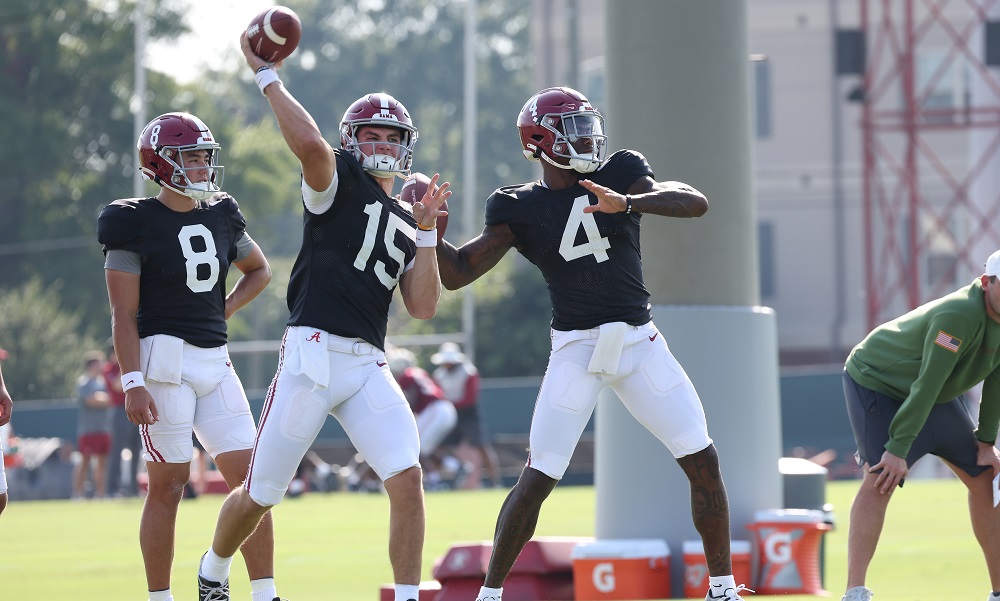 Alabama quarterback Jalen Milroe throws next to Ty Simpson and Tyler Buchner