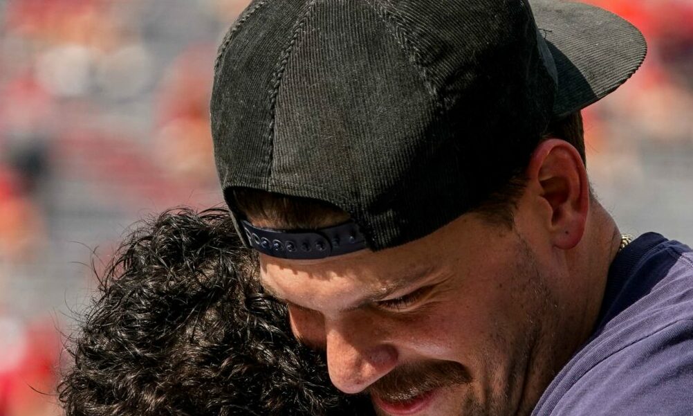 Former Michigan player Taylor Lewan greets Wolverines' RB Bake Corum in 2023 matchup against Nebraska.