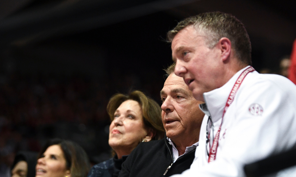 Alabama athletic director Greg Byrne sits with Nick Saban and Miss Terry