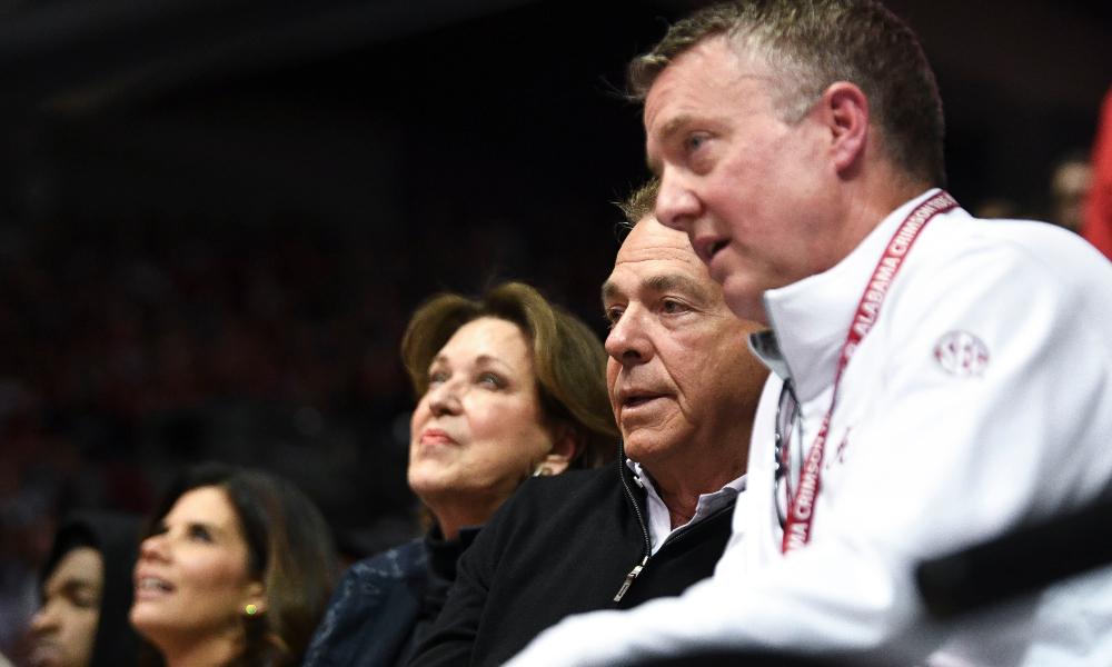 Former Alabama head coach Nick Saban, wife Miss Terry and athletic director Greg Byrne watch the Crimson Tide's basketball team