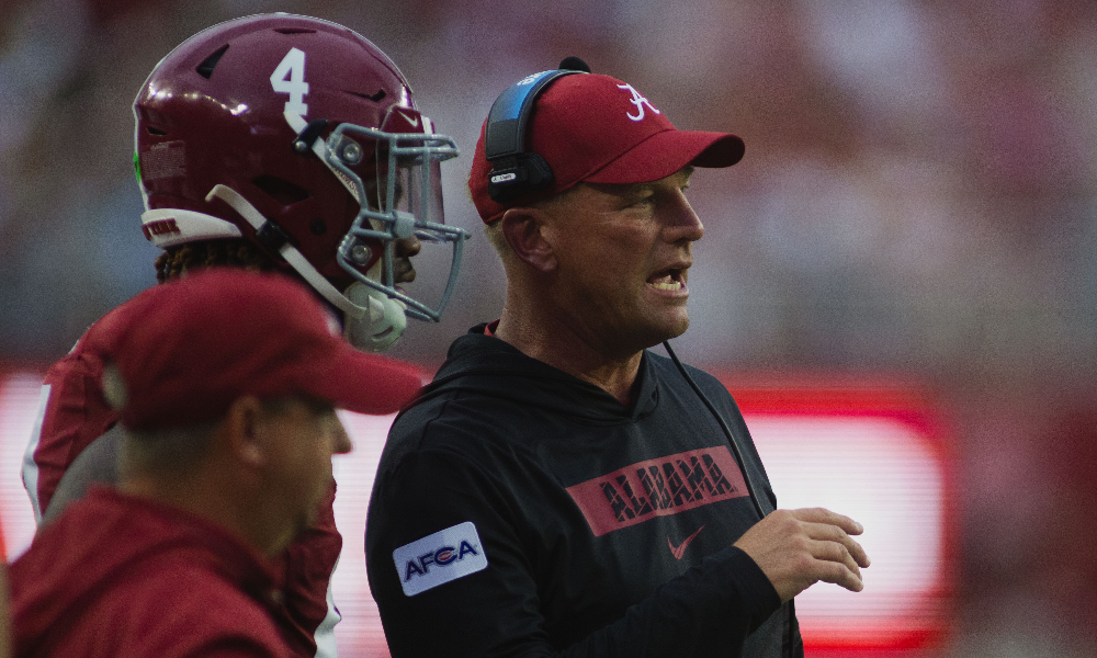 Alabama head coach Kalen DeBoer speaks with Jalen Milroe