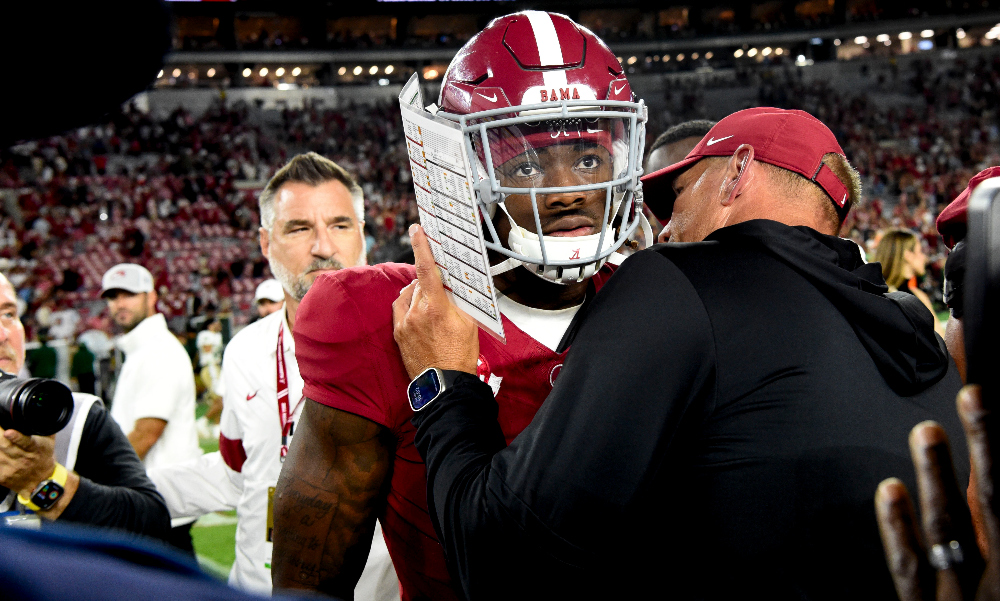 Alabama quarterback Jalen Milroe and head coach Kalen DeBoer talk at midfield