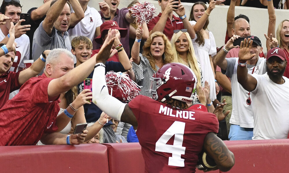 Alabama QB Jalen Milroe (#4) celebrates with Crimson Tide fans after scoring a rushing touchdown against Western Kentucky.