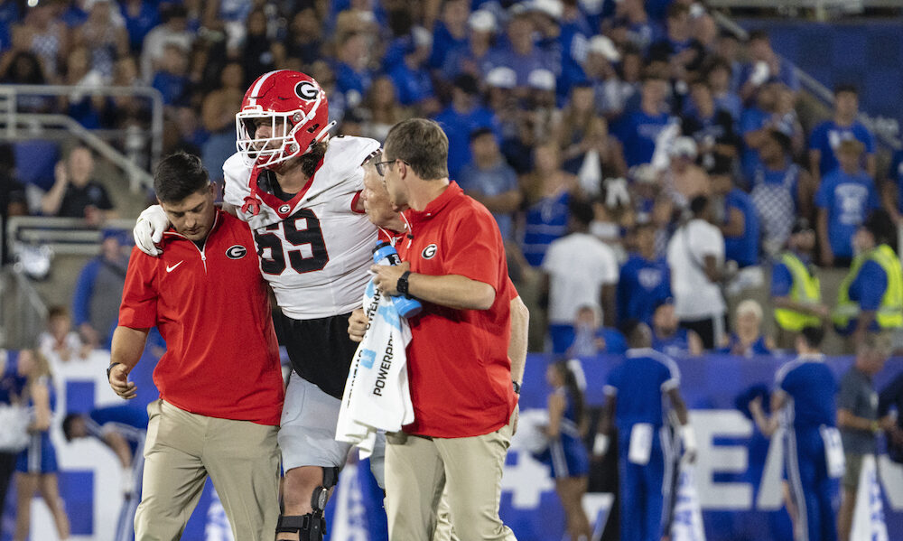 Georgia OL Tate Ratledge (#69) helped off the field after suffering an ankle injury against Kentucky in 2024 matchup.