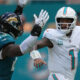 Sep 8, 2024; Miami Gardens, Florida, USA; Miami Dolphins quarterback Tua Tagovailoa (1) rolls out to pass as linebacker Foyesade Oluokun (23) follows on the play at Hard Rock Stadium.