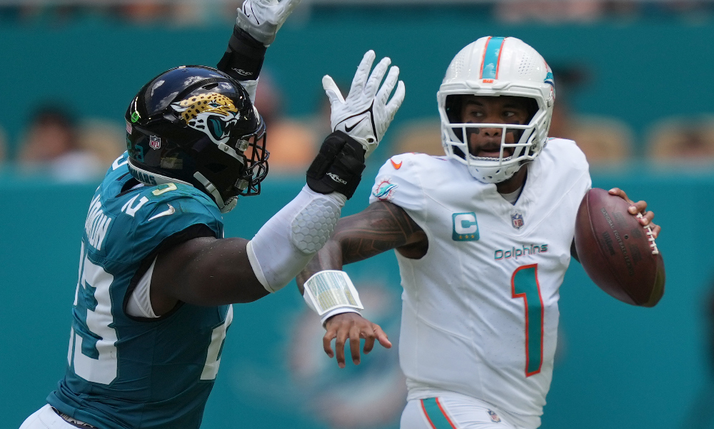 Sep 8, 2024; Miami Gardens, Florida, USA; Miami Dolphins quarterback Tua Tagovailoa (1) rolls out to pass as linebacker Foyesade Oluokun (23) follows on the play at Hard Rock Stadium.