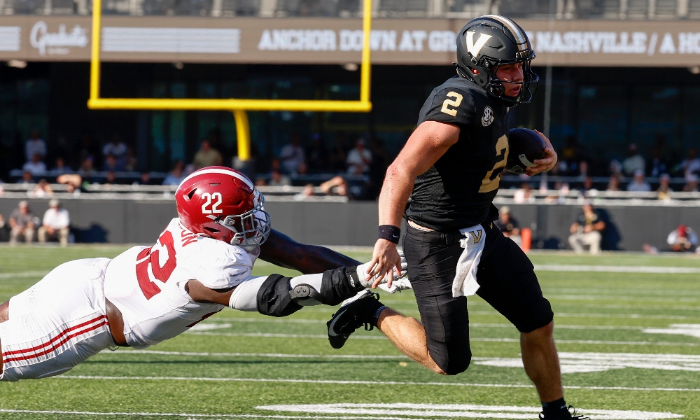 Vanderbilt Commodores quarterback Diego Pavia (2) runs the ball against Alabama Crimson Tide defensive lineman LT Overton (22) during the first half at FirstBank Stadium.