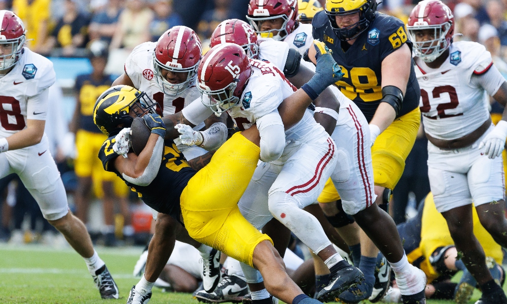 Alabama linebackers Jihaad Campbell and Justin Jefferson tackle Michigan running back Tavierre Dunlap