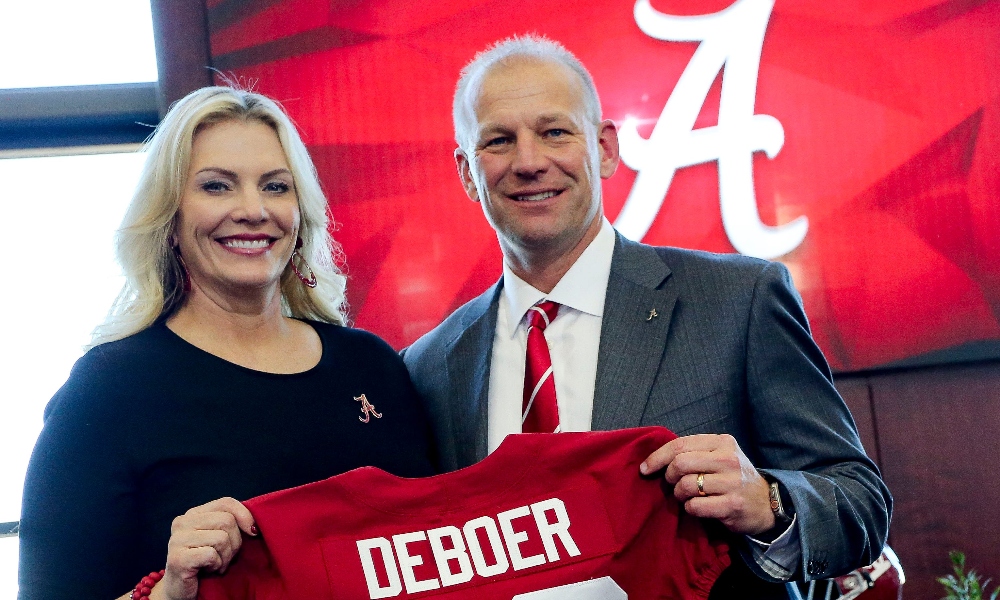 Kalen and Nicole DeBoer hold up jersey as he is introduced as the new Alabama head football coach